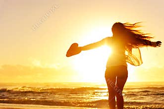Silhouette of a woman dancing by the ocean