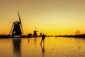 The joyce of living in the rural county and of being able to iceskate on a frozen windmill canal at sunrise moment