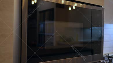 Close-up modern oven in home appliances shop indoors. Black stainless steel tool for food cooking close-up. Household