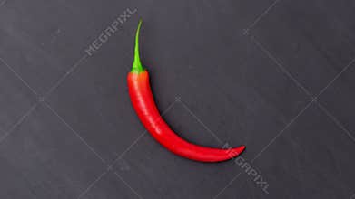 Red chilli peppers over grey concrete background. Spicy food ingredients.