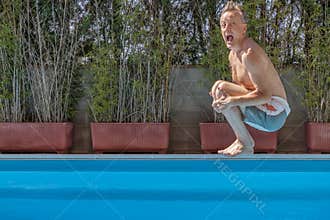 Middle aged white man diving into a swimming pool, cannonball style,with a funny expression