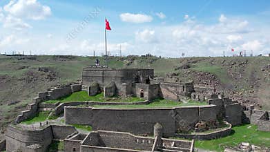 Ancient stone bridge across Kars River & Kars Castle - main tourist attractions of Kars, Turkey. Near flag on castle are portrait