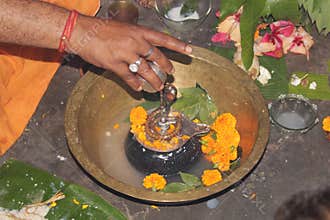Hindu Devotees offering milk And Water to Shiv Lingam on occasion of Abhishekam in India . Offering Flower and bael leafs
