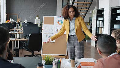 Evil boss Afro-American businesswoman yelling at subordinates during business meeting in office