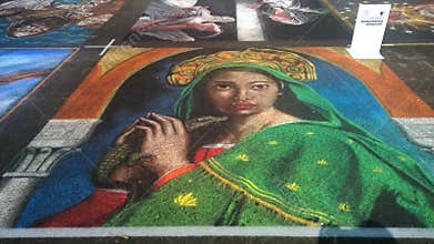 Pavement street artist  painting over the asphalt in Curtatone MN, Italy