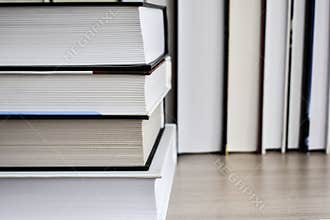 Hardback books on wooden shelf on the deck table, no labels, blank spine. Back to school. Education background