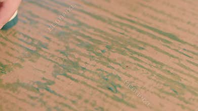 A Young Child Engaged in Drawing with a Colorful Crayon on a Textured Wooden Surface