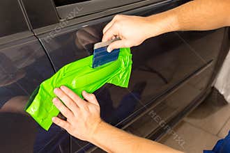 Car wrapping specialist wraps car door handle with adhesive foil or film