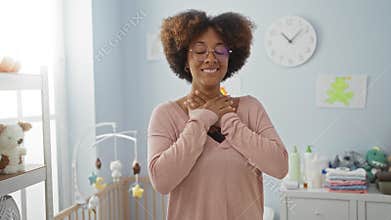 Woman\'s surprised face with open mouth signaling amazement and disbelief as she stands in a baby room, african american lady in