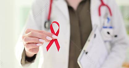 Lady doctor shows red ribbon for Worlds AIDS Day in clinic