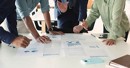Businesspeople analyzing report shown in charts, graphs and diagrams