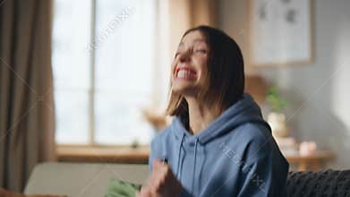 Emotional girl cheering tv game sitting home sofa closeup. Excited woman raising
