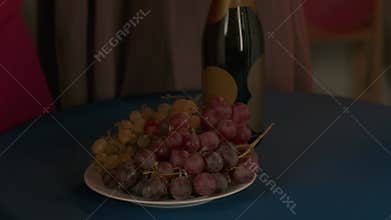 Group of young women friends celebrating bachelorette party at home, bridesmaids and bride eating grapes and drinking