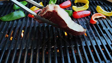 T- bone steak grill turn over on barbecue. Slow motion