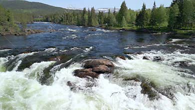 Sweeping rightward, a drone hovers low over the cascading Namsen River in Namsskogan, Norway