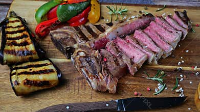 T- bone beef steak grilled sliced with grilled vegetables rotate wooden cutting board