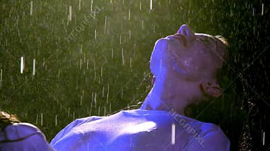 Glad lady incurves turning face to rain to absorb moisture