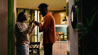 Black boyfriend seeing her girlfriend laugh at mobile phone screen