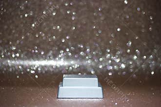 Shiny surface with a small rectangular object in a simple setting during a light sparkle event