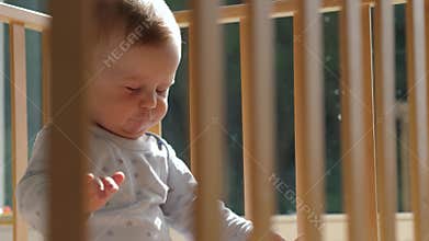A Playful Baby Enjoys Time in a Crib