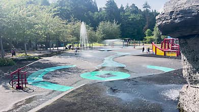 Families enjoy water playground splash pad in Stanley Park, Vancouver