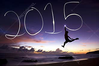Happy new year 2015.young man jumping and drawing 2015