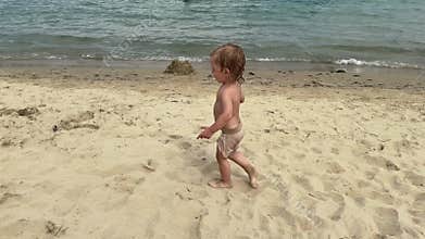 Toddler beach discovery with ball