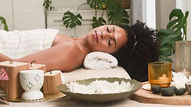 Serene Black Woman Enjoys a Relaxing Spa Treatment with Natural Elements