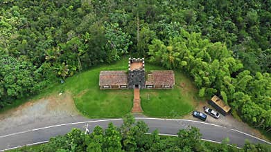 Top-down view capturing the circular form of Santa Ana Stone Tower, winding road, and two still cars
