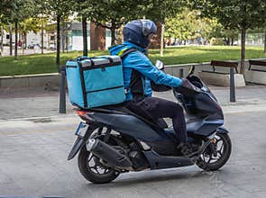 Food delivery courier on scooter in the city