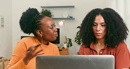 Diverse Professional Women Discussing Startup Tech Ideas on a Laptop