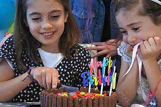 Birthday girl cutting a birthday party cake