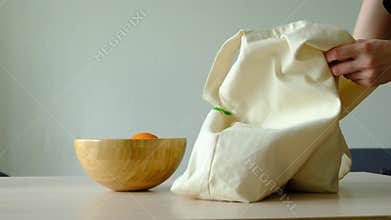 Hand stacks fruits in a bowl