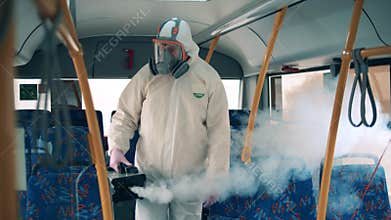 A disinfector sprays a bus during coronavirus pandemic.
