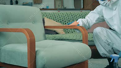 Sanitation worker wipes a chair with sanitizer to kill virus. Antibacterial sanitizer used during covid 19 pandemic.