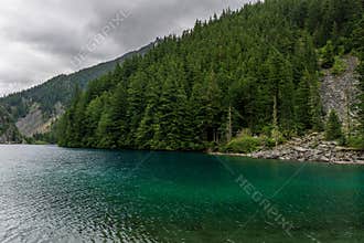 Beautiful mountain Lindeman lake green forest and cloudy sky british columbia canada