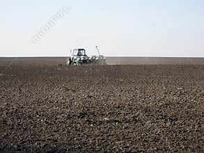 Plowed field by tractor in brown soil on open countryside nature