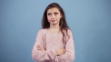Portrait of irritated long haired teen girl rolling her eyes while being fed up or bored, isolated over blue background