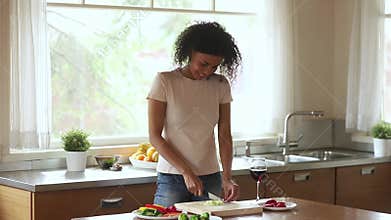 Happy young african woman vegetarian prepare salad meal at home