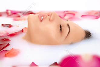 Attractive girl takes a bath with milk