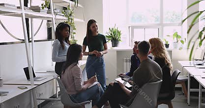 Young female leader discuss project plan with diverse colleagues team