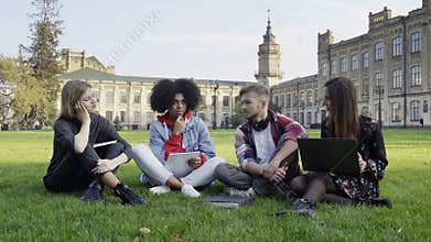 4 Students on the Grass at College Campus with Laptop