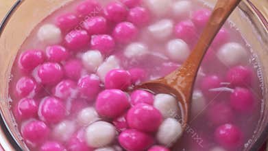 Boiling Tang yuan, tangyuan, delicious red and white rice dumpling balls in a glass pot. Concept of cooking at home for Winter Sol