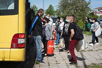 People getting off and boarding the city bus at the bus stop