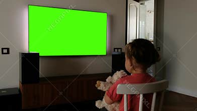 Child in front of a green screen TV