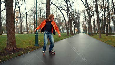 Experienced bearded male skater technically and virusically performs complex U-turns and tricks on the asphalt road of a