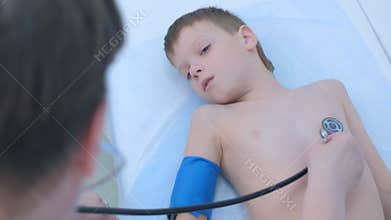 Pediatrician cardiologist listening heartbeat of child boy using stethoscope.