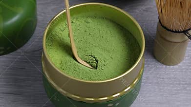 Scoop of green matcha tea with a traditional bamboo spoon