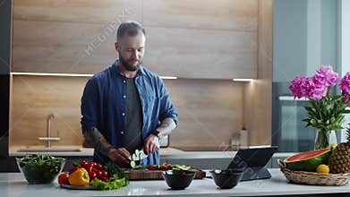 Carefree Man Listens to Music From His Headphones and Cuts Vegetables.
