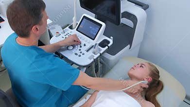Man doctor examining patient`s woman thyroid gland using ultrasound scanner.